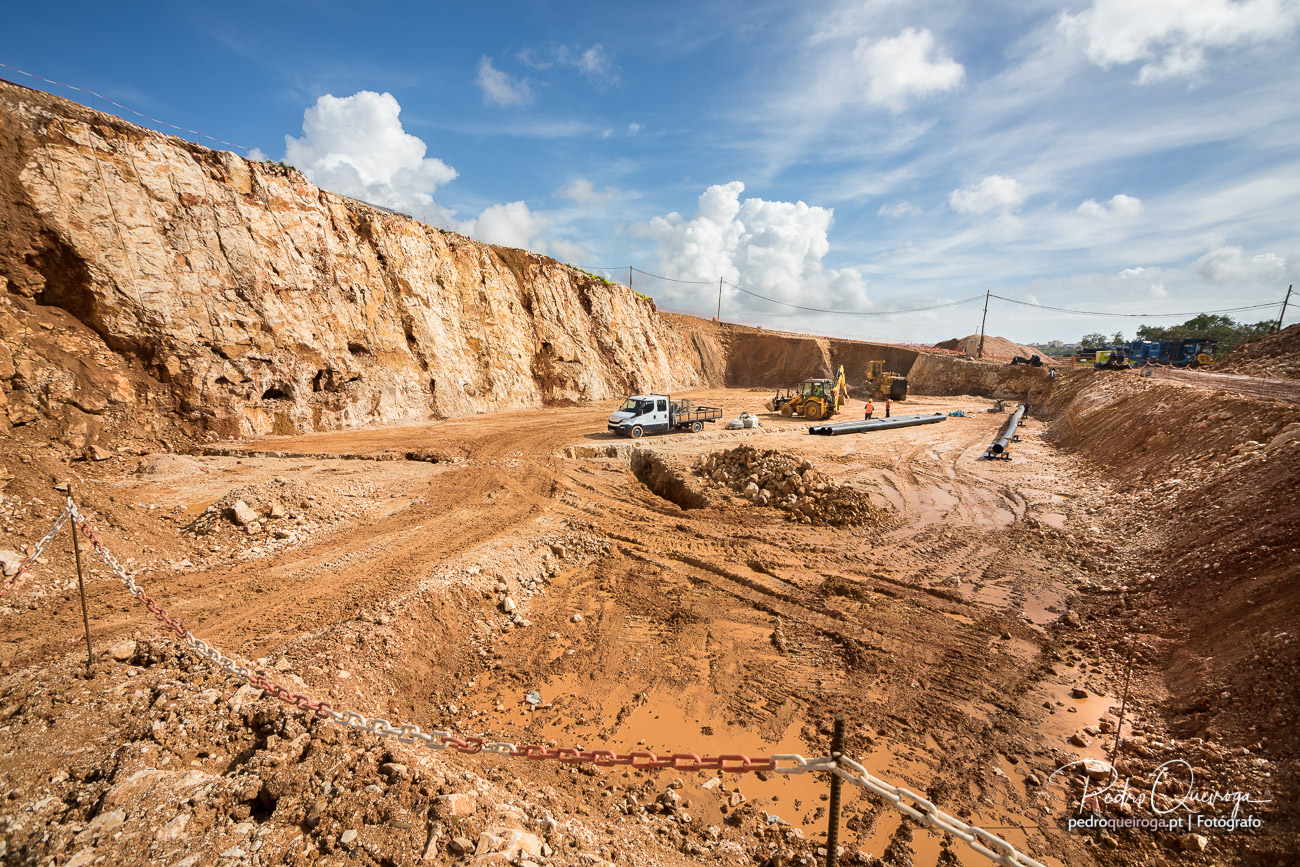 Escavação em rocha com frente de corte e maquinaria pesada em obra de infraestruturas