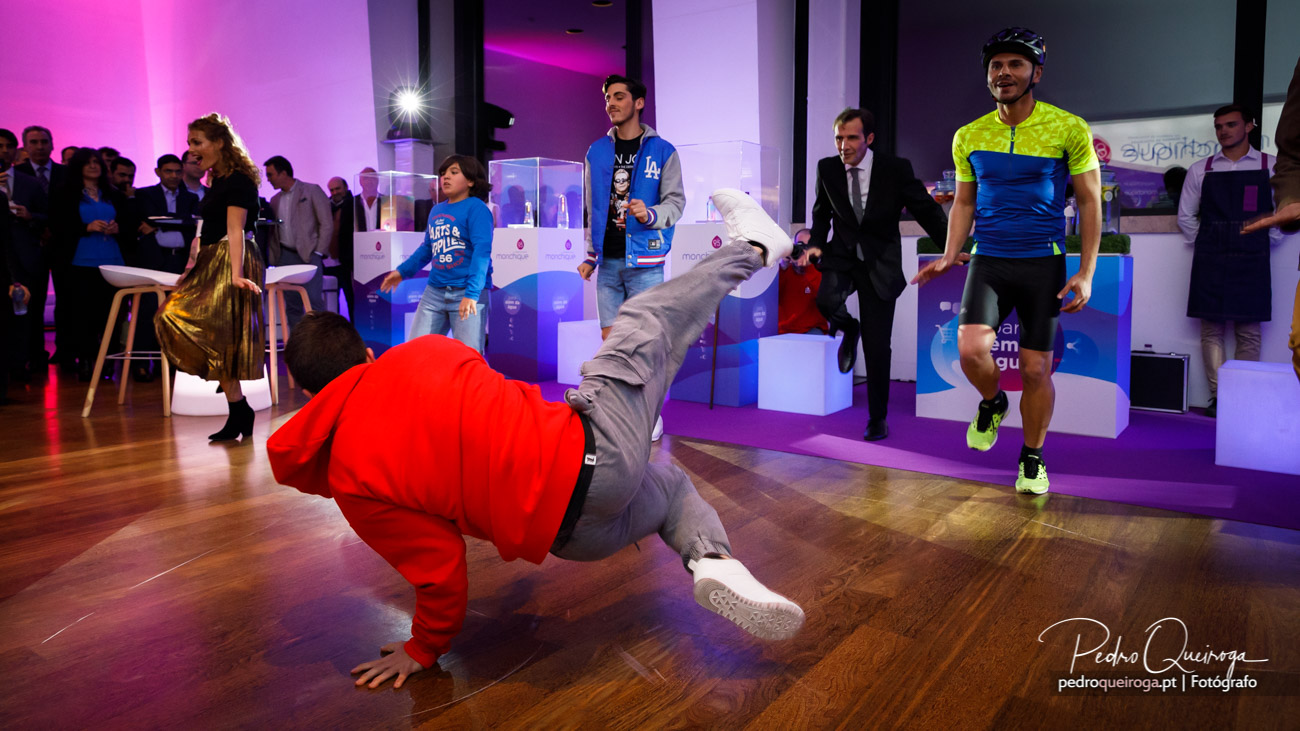 Dançarino de breakdance em performance acrobática durante evento corporativo num hotel moderno em Portugal