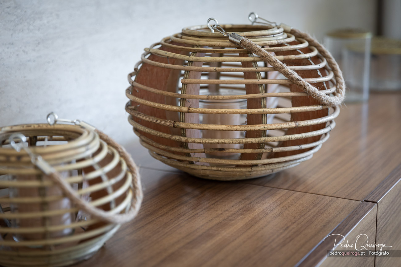 Lanternas decorativas em vime natural dispostas sobre móvel de madeira em ambiente contemporâneo e minimalista