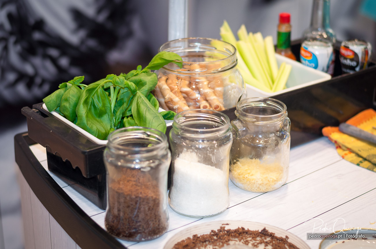 Ingredientes frescos e frascos de vidro organizados numa bancada de cozinha para fotografias gastronómicas