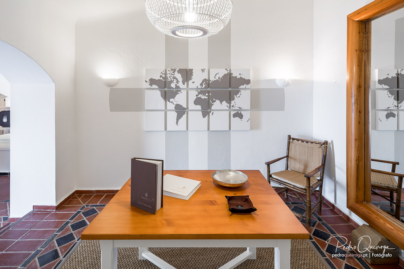 Sala de jantar moderna com mesa laranja, cadeiras em palhinha e mapa-mundo decorativo na parede branca
