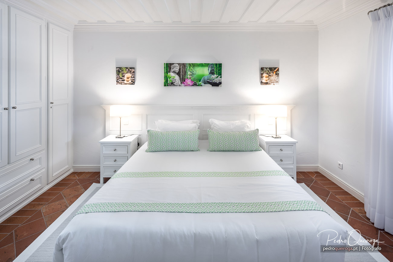Quarto branco elegante com detalhes verdes, ideal para fotografia de interiores de hotéis e alojamento turístico