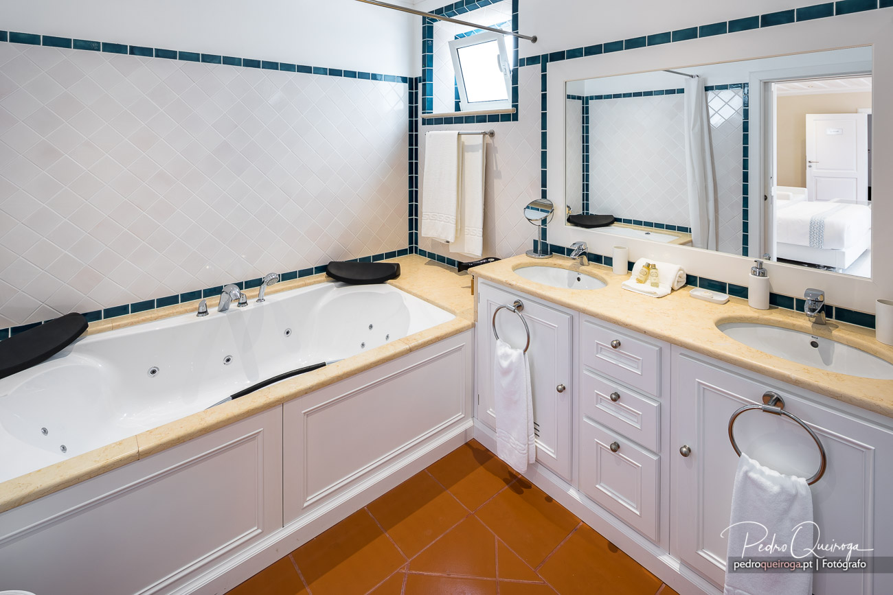 Casa de banho elegante com banheira de hidromassagem e dois lavatórios, captada por fotógrafo profissional