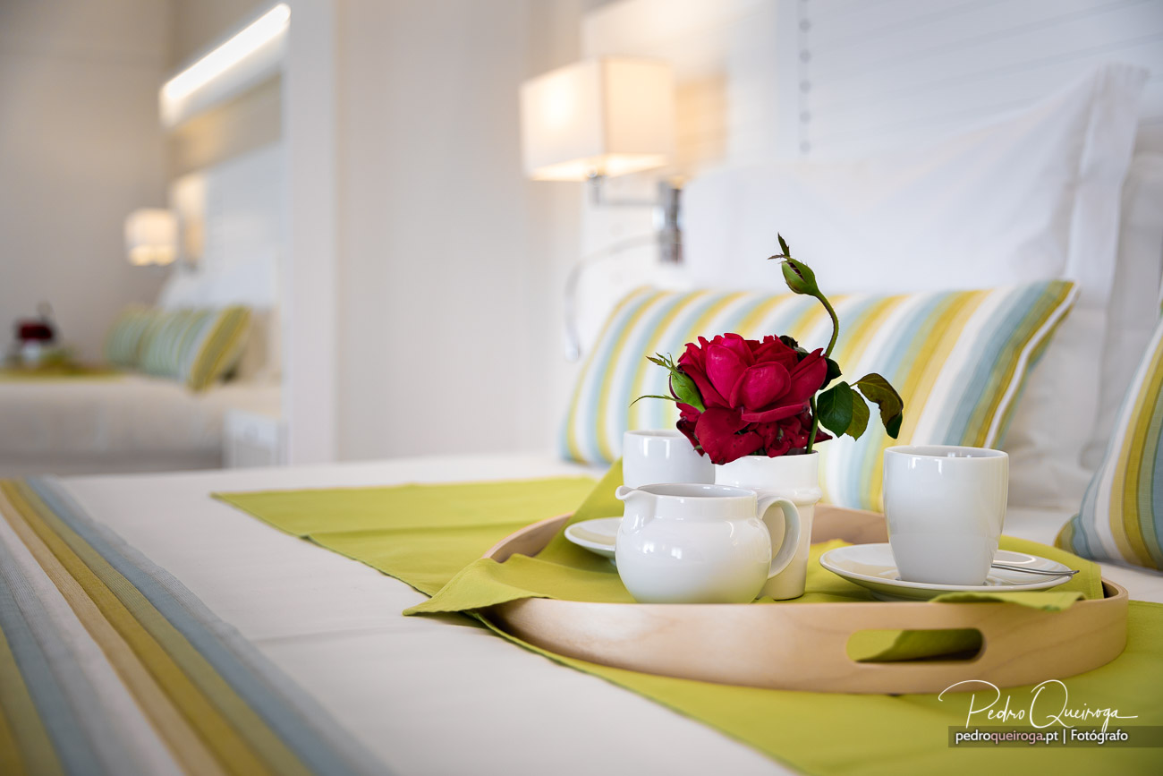 Quarto acolhedor com tabuleiro de pequeno-almoço e rosa vermelha, fotografia de Pedro Queiroga
