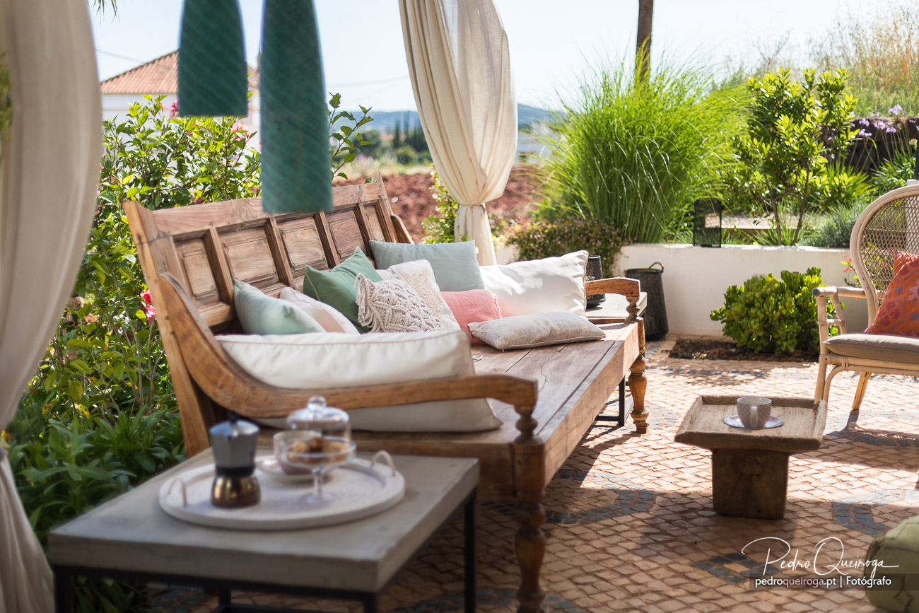 Terraço acolhedor com cama balinesa, almofadas coloridas e vegetação exuberante em composições fotográficas elegantes