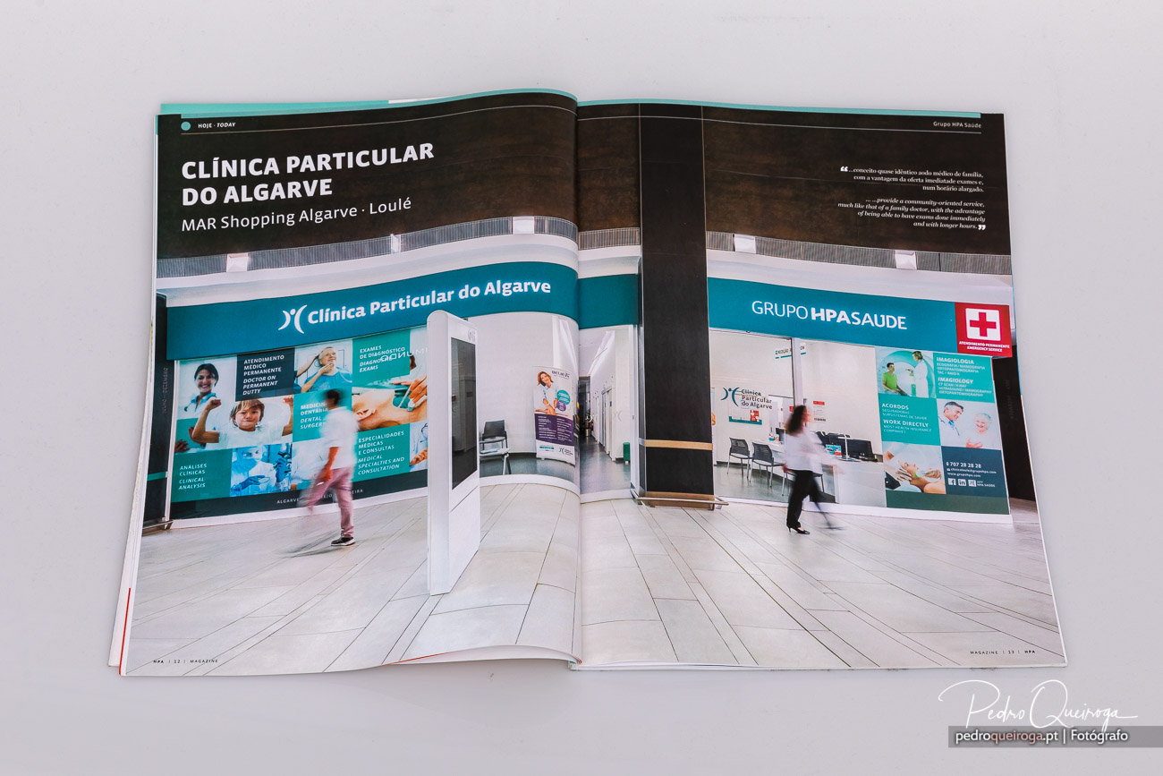 Dupla página de revista aberta mostra fachada moderna da Clínica Particular do Algarve em centro comercial