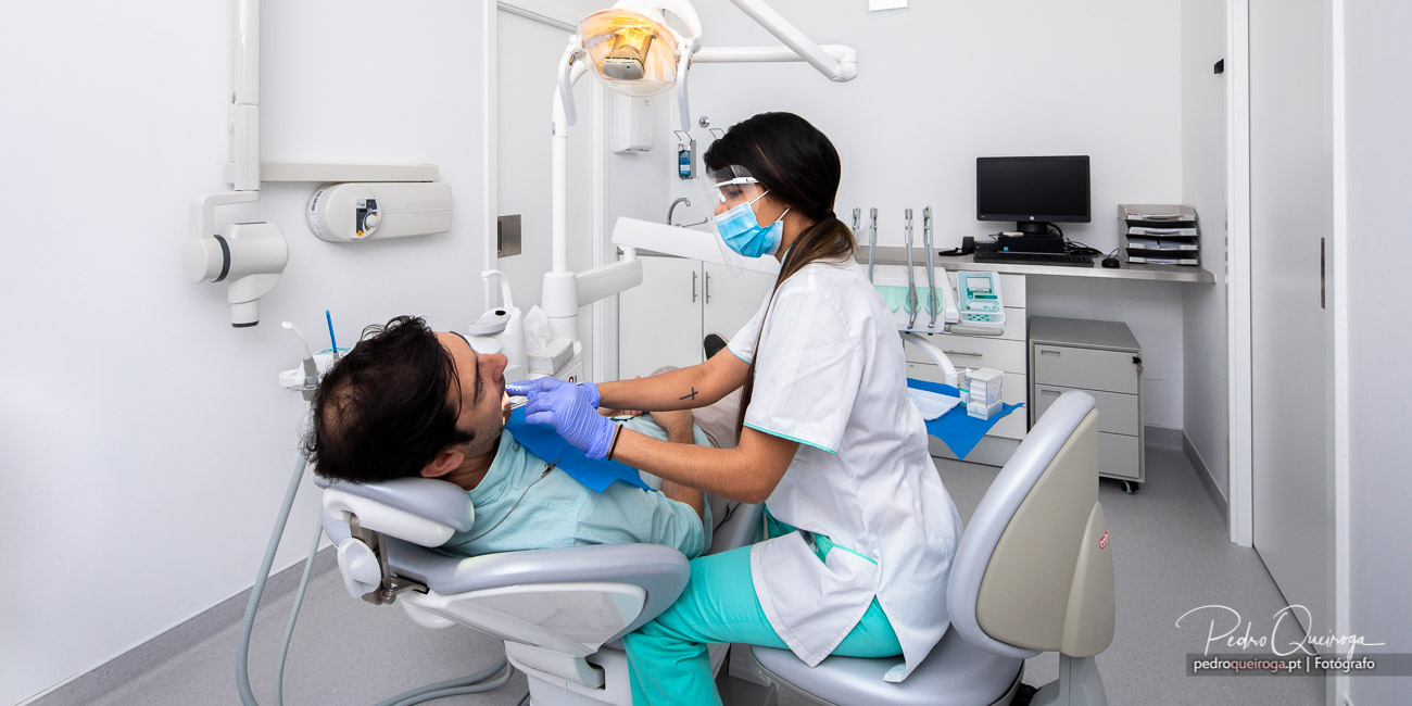 Dentista realiza tratamento a paciente em consultório moderno e luminoso equipado com tecnologia avançada