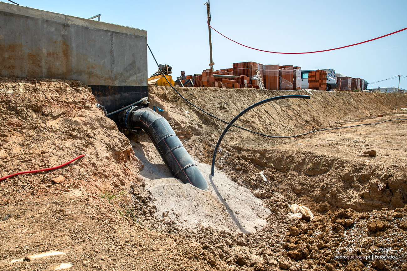 Conduta de PEAD em curva a ser instalada em escavação junto a estrutura de betão em estaleiro de obras