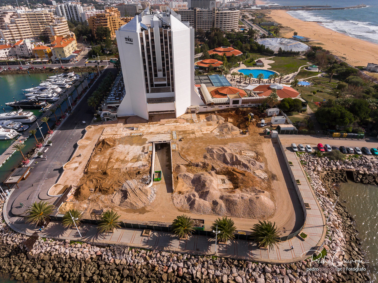 Vista aérea do terreno completamente limpo após demolição junto ao Hotel Tivoli Marina Vilamoura com praia e oceano ao fundo