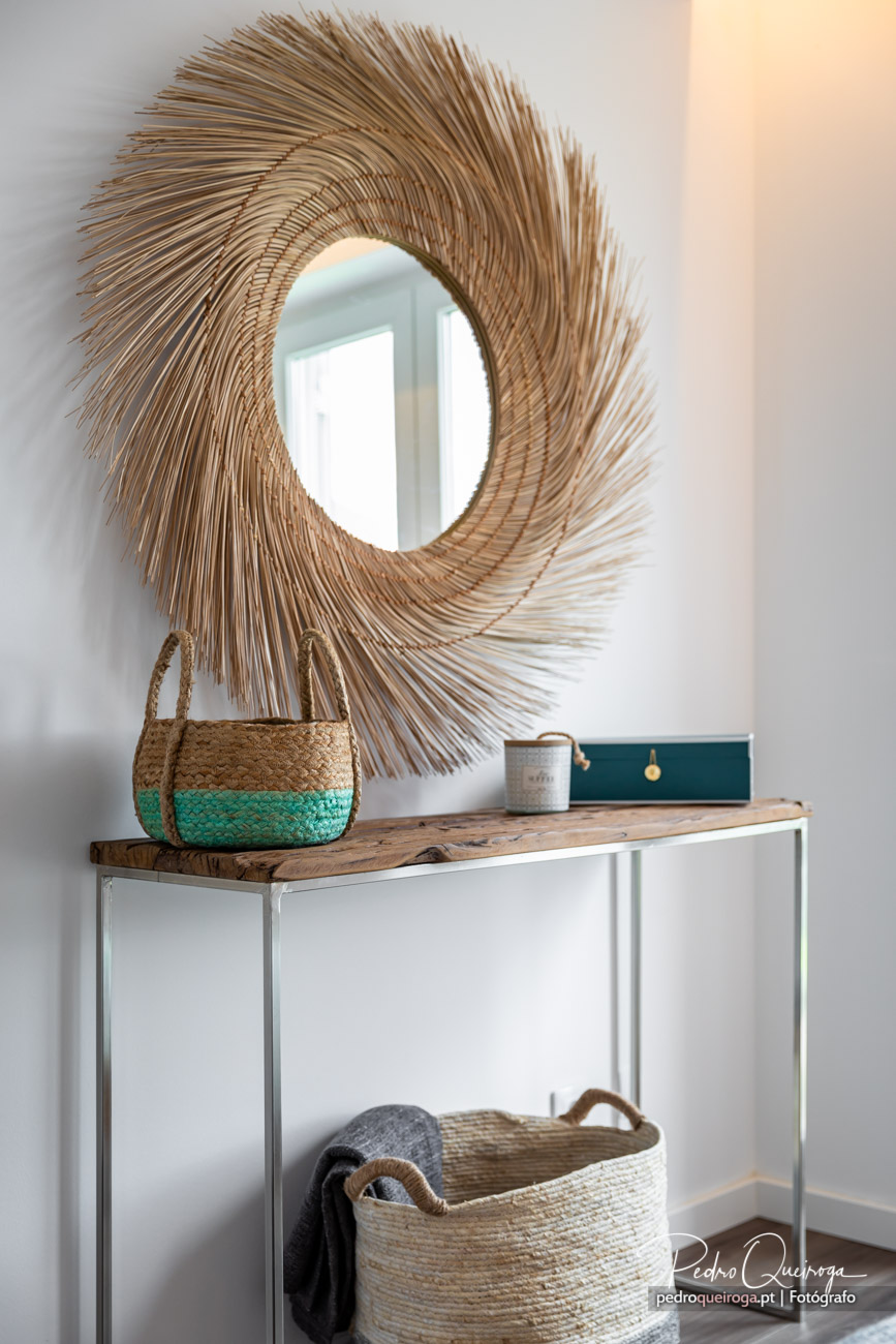 Espelho redondo com moldura em fibra natural sobre consola minimalista, fotografias de interiores com estilo boho