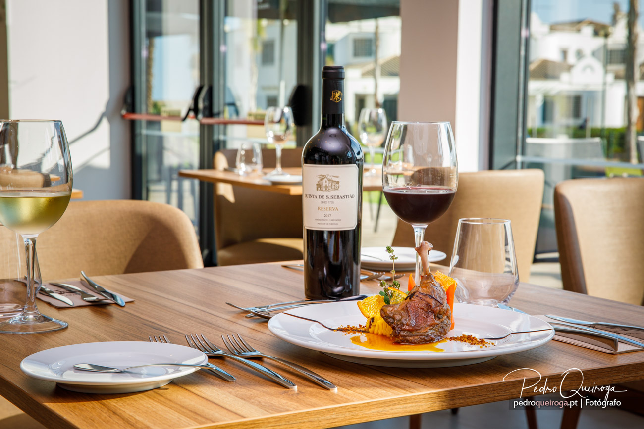 Mesa elegante com vinho tinto Quinta de S. Sebastião e prato gourmet num restaurante de hotel sofisticado