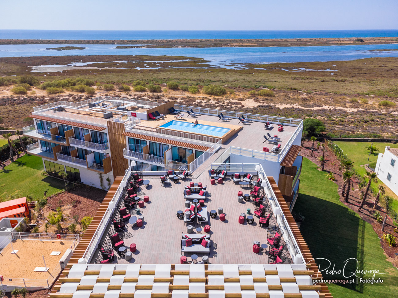Hotel moderno com piscina e terraço virado para a Ria Formosa no Algarve, rodeado por natureza preservada.