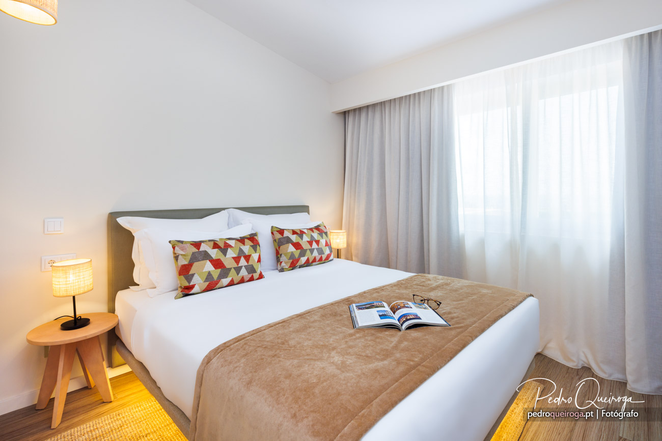 Quarto moderno e acolhedor com almofadas coloridas e luz natural num hotel no Algarve