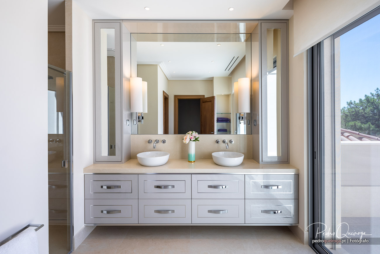 Casa de banho moderna com duplo lavatório e espelho amplo, destacada em reportagens fotográficas de interiores