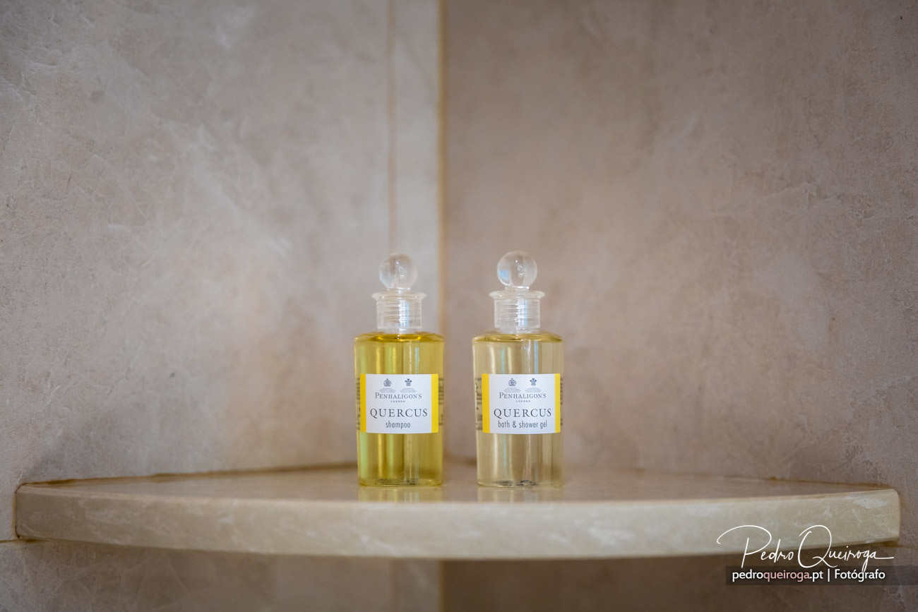 Dois frascos transparentes de champô e gel de banho Quercus da Penhaligon's sobre prateleira em mármore bege