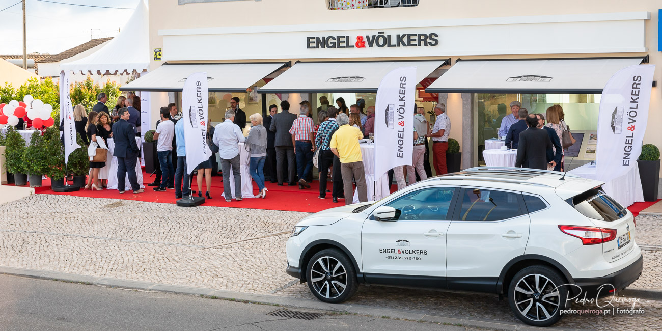 Inauguração da loja Engel & Völkers com convidados sobre passadeira vermelha e arquitetura contemporânea ao fundo