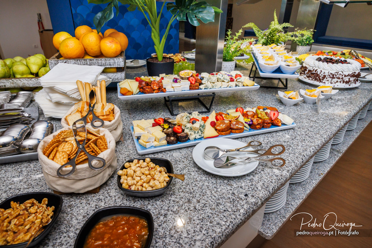 Buffet de pequeno-almoço repleto de queijos, bolachas, fruta fresca, doces e bolo num balcão de granito elegante