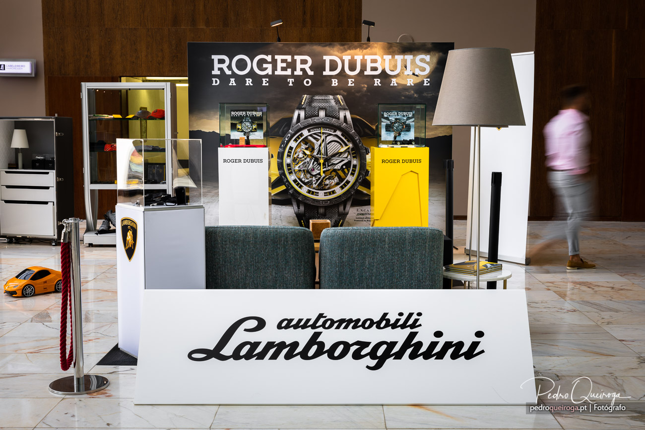 Stand promocional Roger Dubuis e Lamborghini em espaço imobiliário de luxo com decoração moderna e elegante