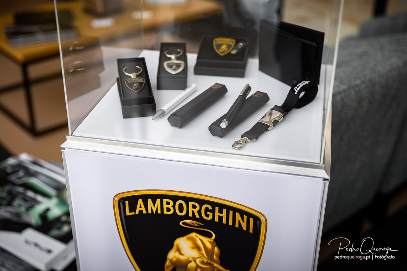 Vitrine expositora Lamborghini com porta-chaves e acessórios premium sobre base branca com logótipo icónico dourado