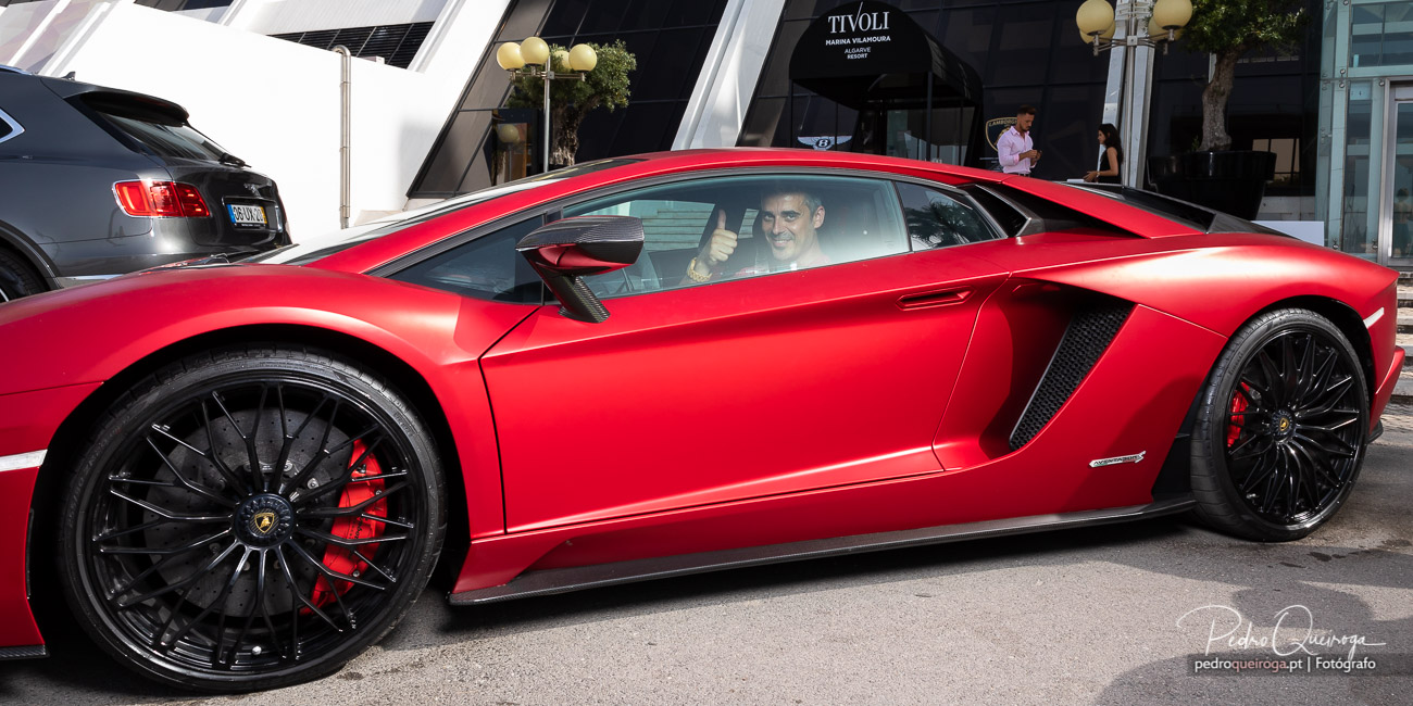 Lamborghini Aventador vermelho estacionado na rua, condutor a fazer sinal de positivo através do vidro lateral