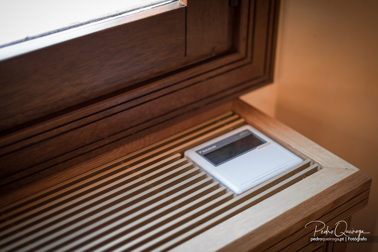 Peitoril de janela em madeira com grelha de ventilação e comando digital branco integrado