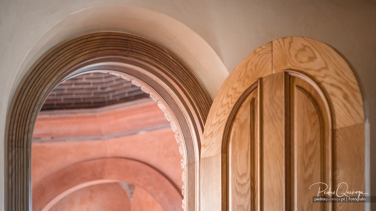 Arcos sobrepostos em tons terrosos e madeira clara criam uma composição arquitetónica minimalista e elegante