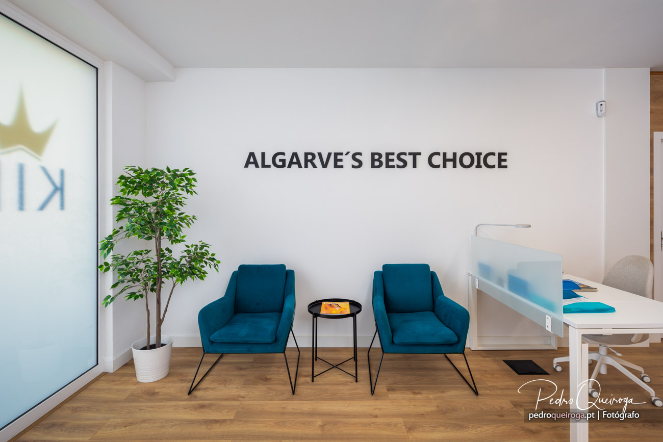 Sala de espera moderna com duas poltronas azul petróleo, planta decorativa e inscrição Algarve's Best Choice na parede branca