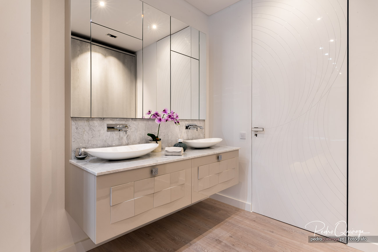 Casa de banho moderna com duplo lavatório oval, móvel suspenso em tons claros e parede decorativa com relevo ondulado