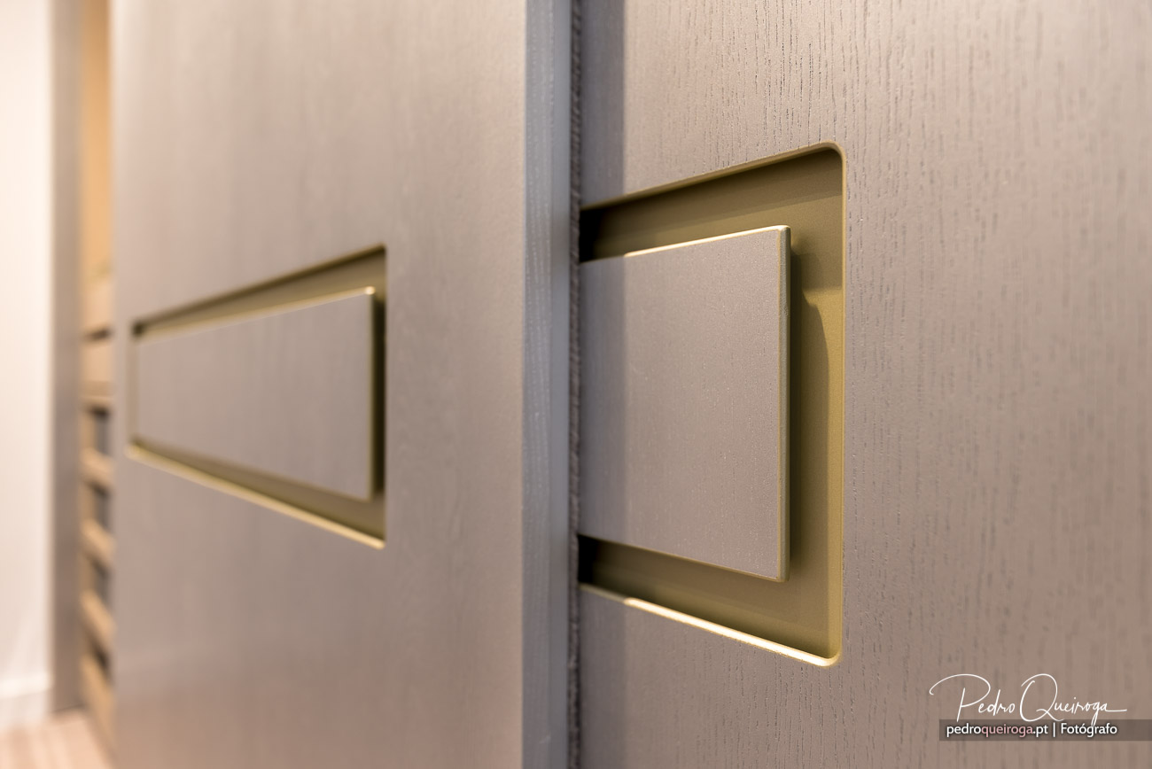 Interruptor moderno com moldura dourada instalado em parede texturizada bege de interior contemporâneo