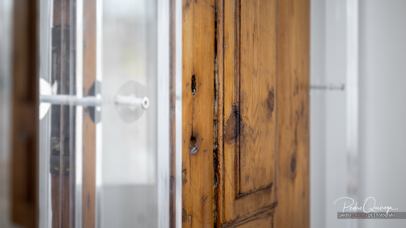 Porta de madeira antiga entreaberta com textura rústica, ideal para fotografias de interiores com carácter