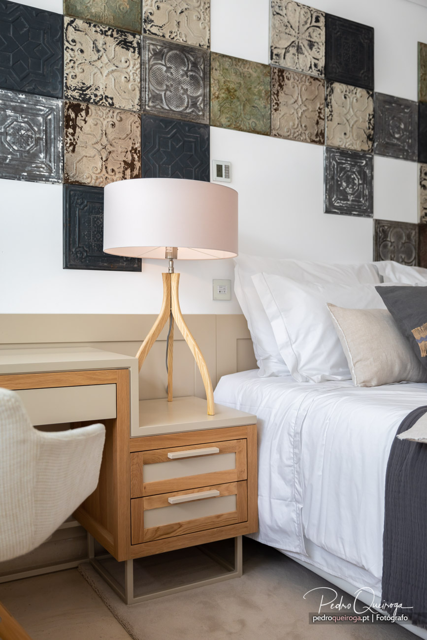Quarto elegante com painel de azulejos vintage, mesinha de cabeceira em madeira e composição fotográfica luminosa