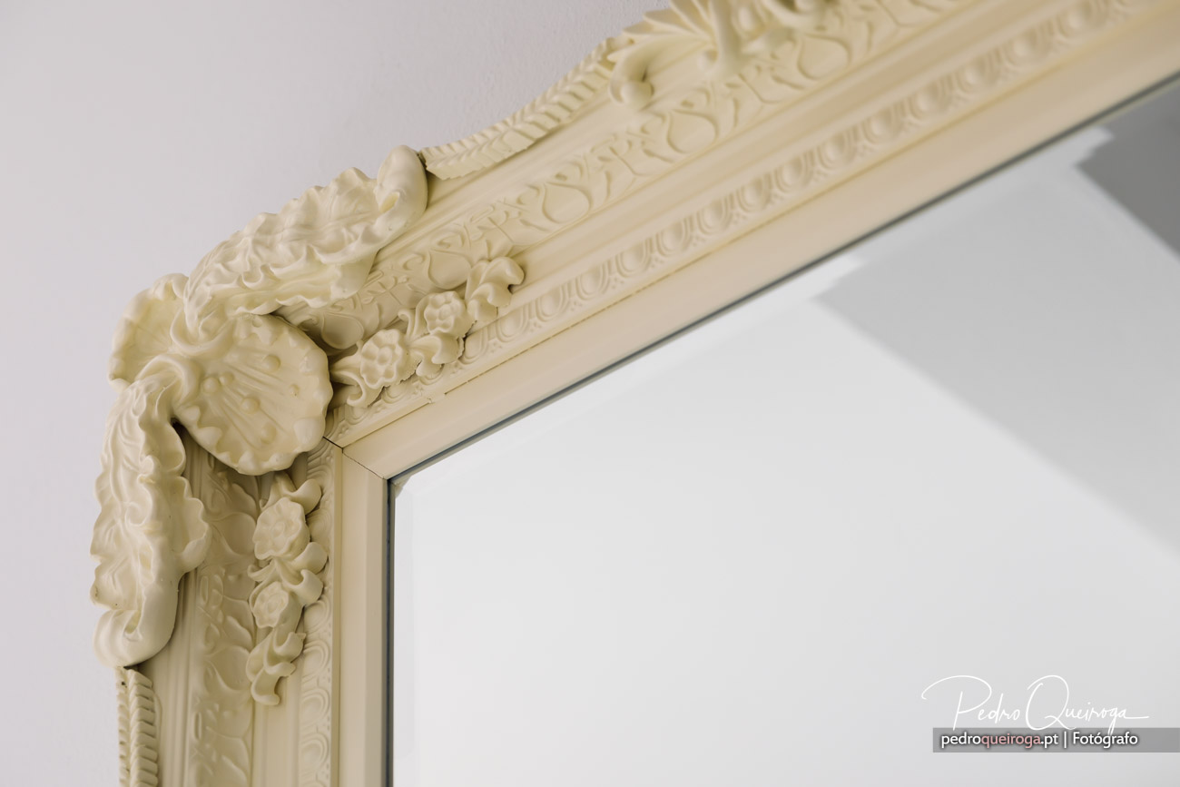 Detalhe de moldura clássica bege com ornamentos florais, típica da arquitetura refinada do Algarve.