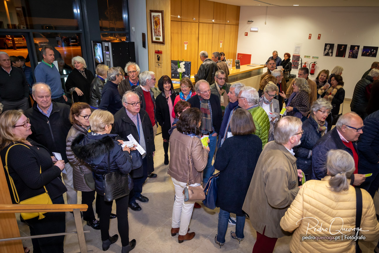Grupo de pessoas reunidas no átrio de um edifício moderno durante evento cultural ou inauguração