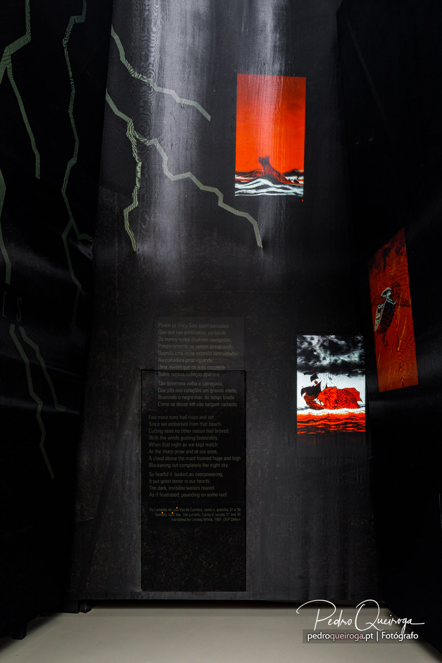 Parede escura de imóvel com arte urbana, ilustrações vermelhas e texto poético em fundo negro industrial.