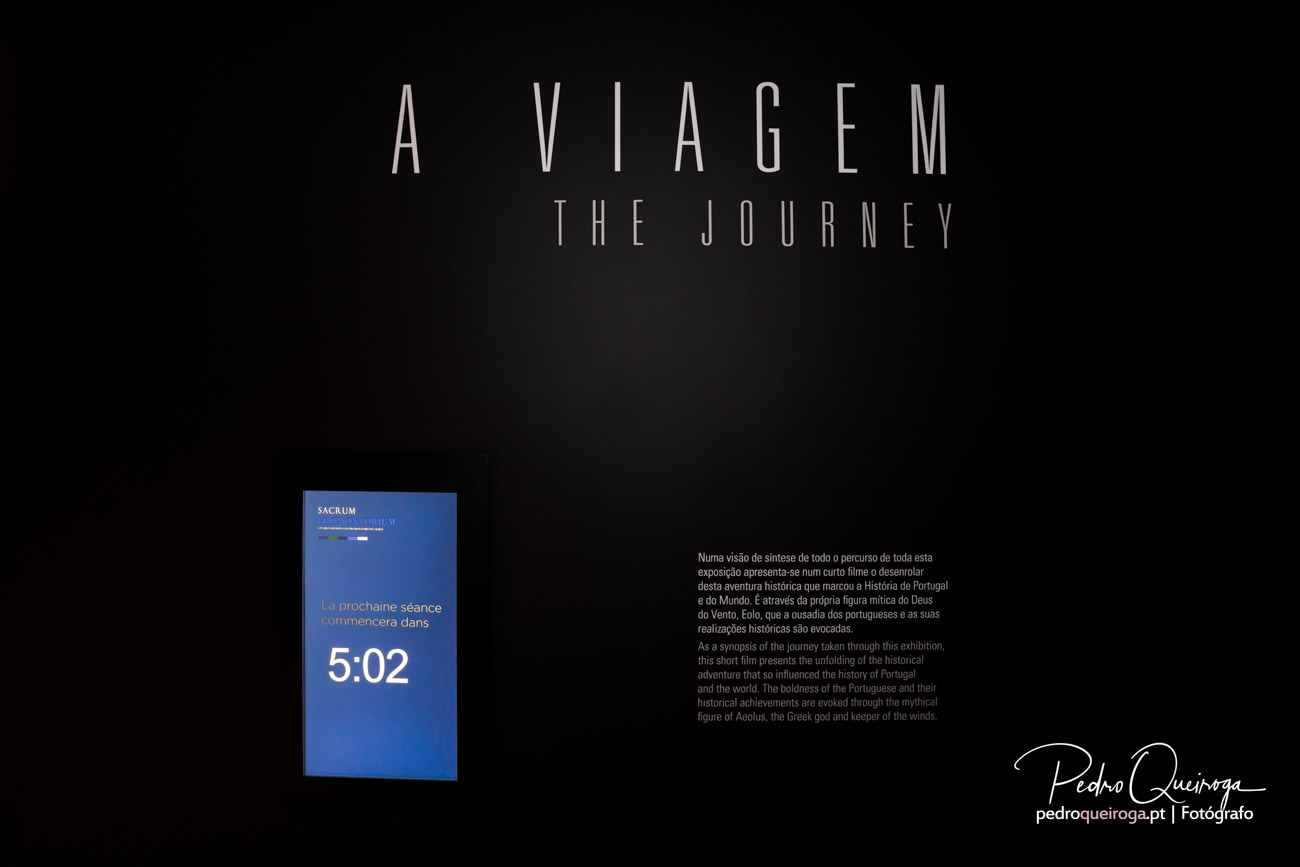 Ecrã expositivo da exposição A Viagem captado por Pedro Queiroga com título e sinopse sobre a história de Portugal