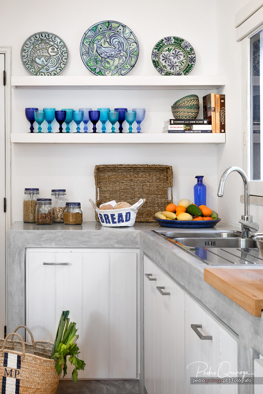 Cozinha moderna com pratos decorativos, copos azuis e fruta fresca, ideal para fotografia de hotéis e alojamento local