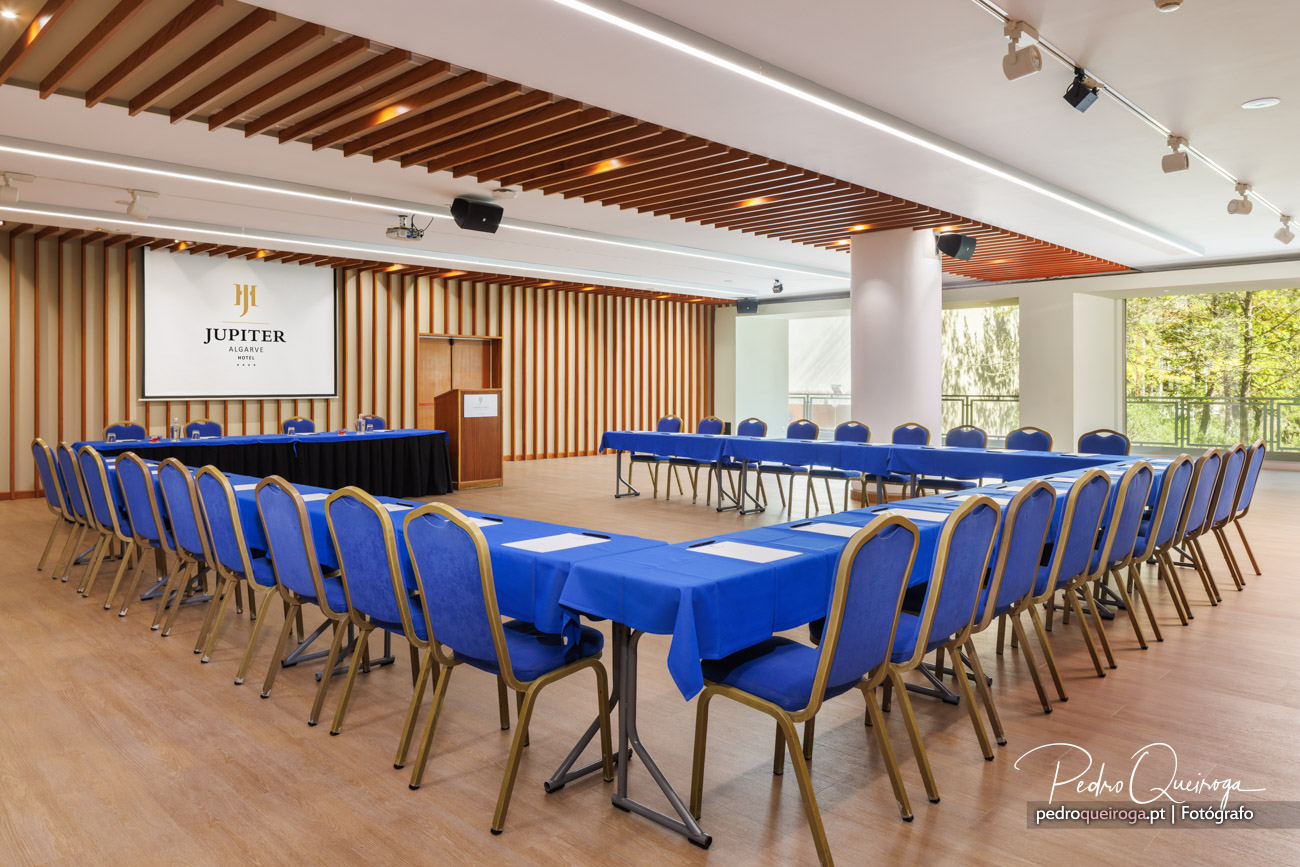 Sala de conferências do Jupiter Algarve com mesas em U e cadeiras azuis, ideal para fotografias corporativas