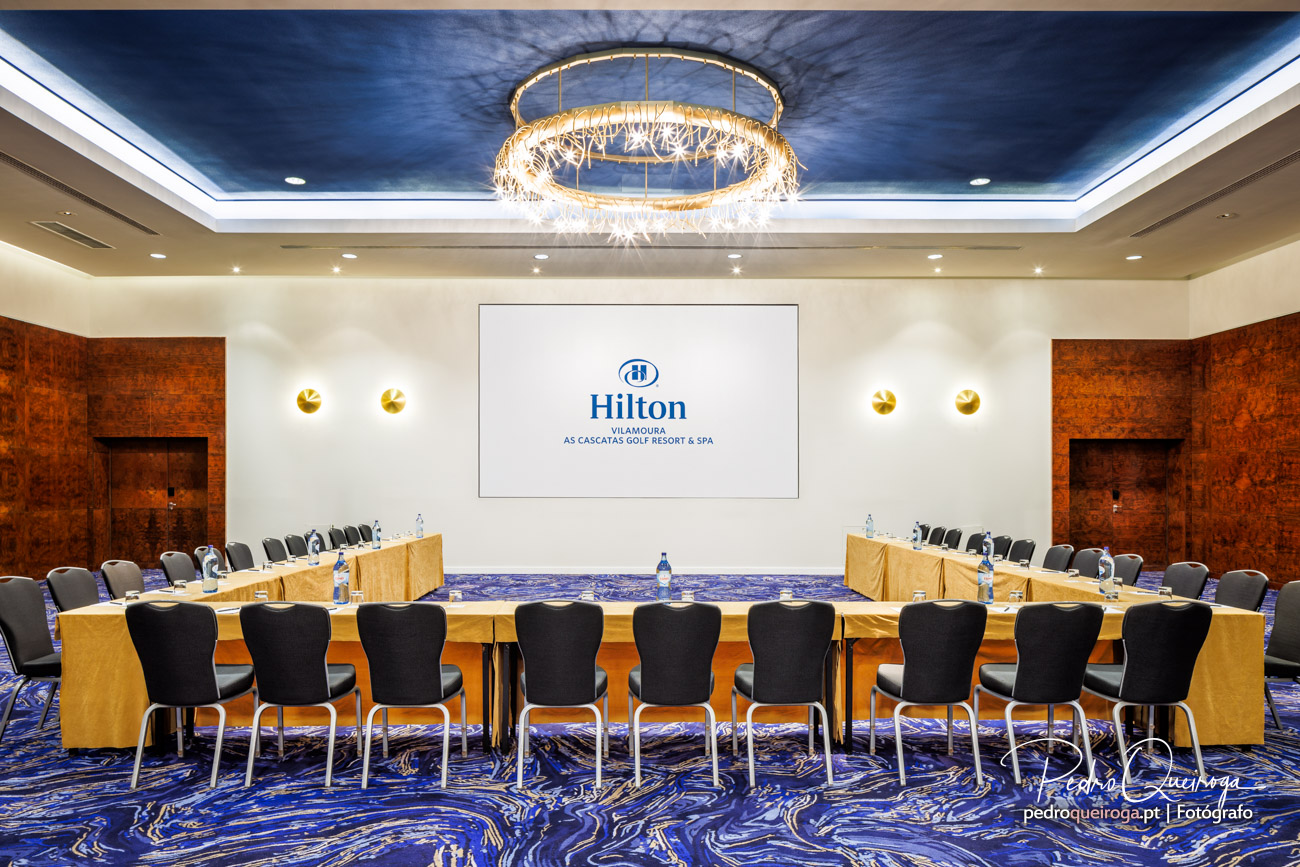Mesa de reuniões corporativa com cadeiras ergonómicas e iluminação profissional no Hotel Hilton