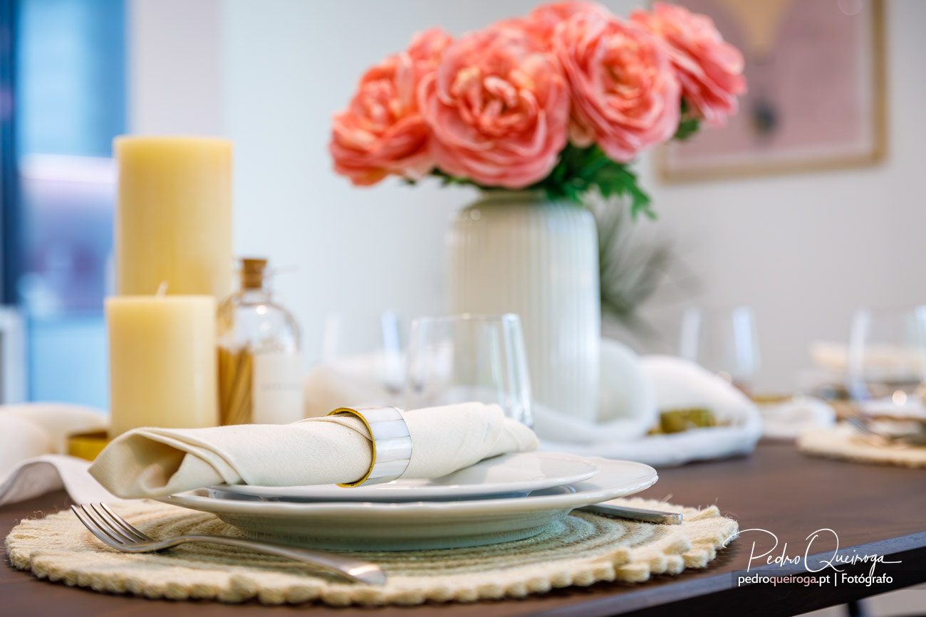 pormenor da mesa de jantar com um prato e um vaso de flores